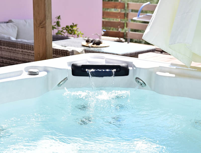 Un jacuzzi extérieur bouillonnant invite à la détente sous un voile blanc léger, avec une ambiance cosy. Un jacuzzi extérieur bouillonnant invite à la détente sous un voile blanc léger, avec une ambiance cosy.