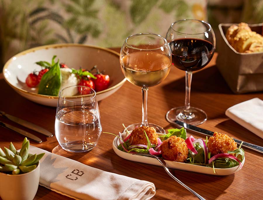 Casa Barbara met en avant une assiette raffinée accompagnée de verres de vin élégants.