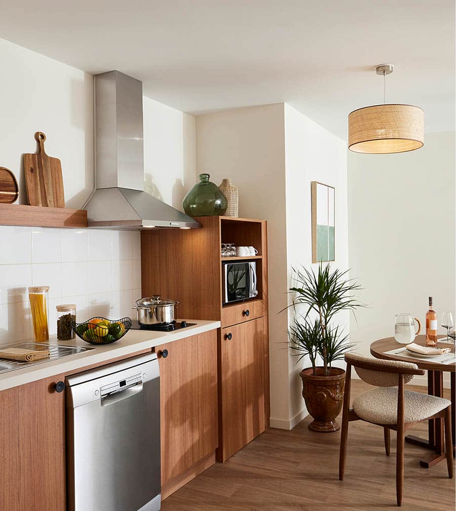 Cuisine compacte et fonctionnelle en bois clair, parfaitement équipée pour une vie autonome avec style. Cuisine compacte et fonctionnelle en bois clair, parfaitement équipée pour une vie autonome avec style.