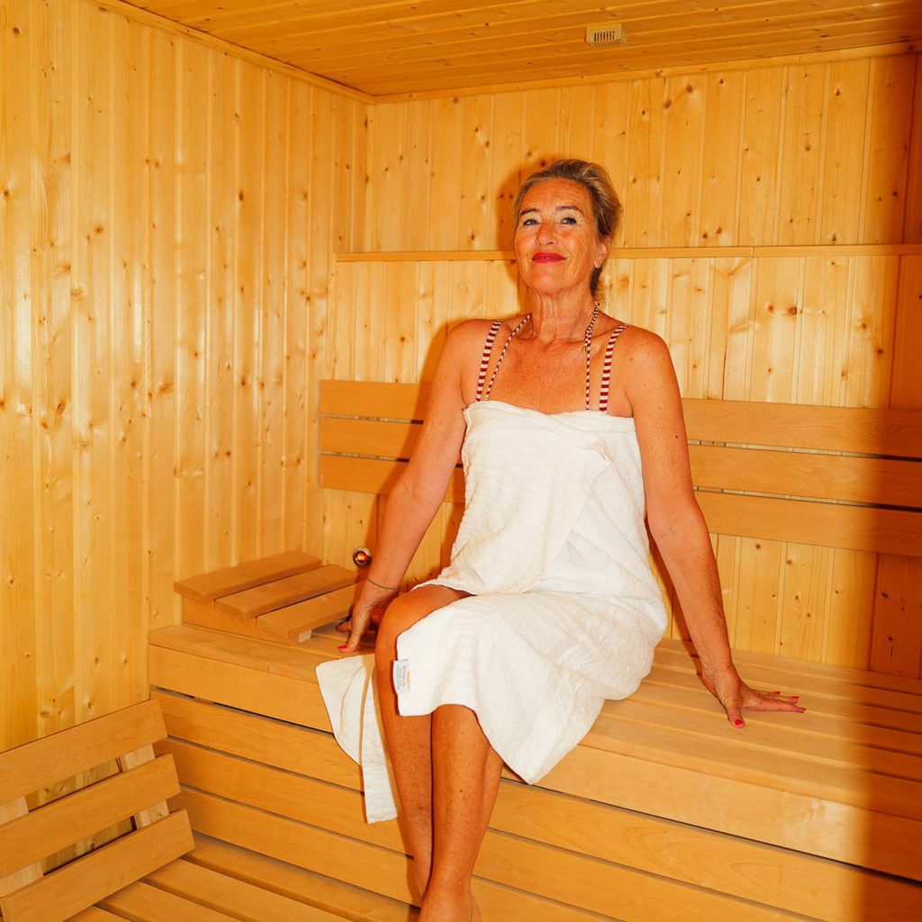 Femme profitant de la chaleur douce du sauna Femme profitant de la chaleur douce du sauna